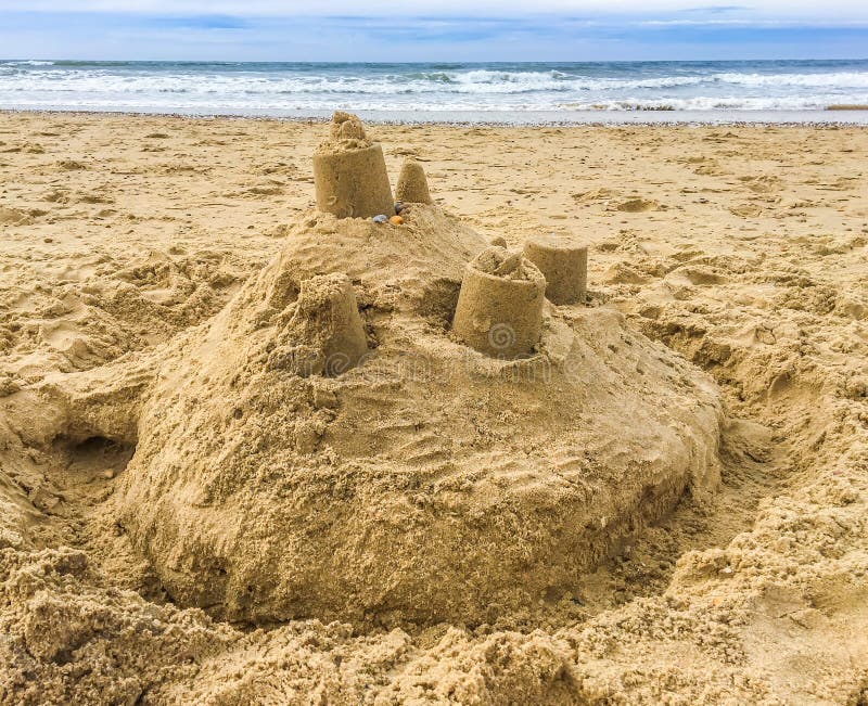 A Sand castle building with towers on the beach with view on the sea