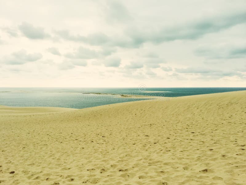 Sand dunes, sea and cloudy sky