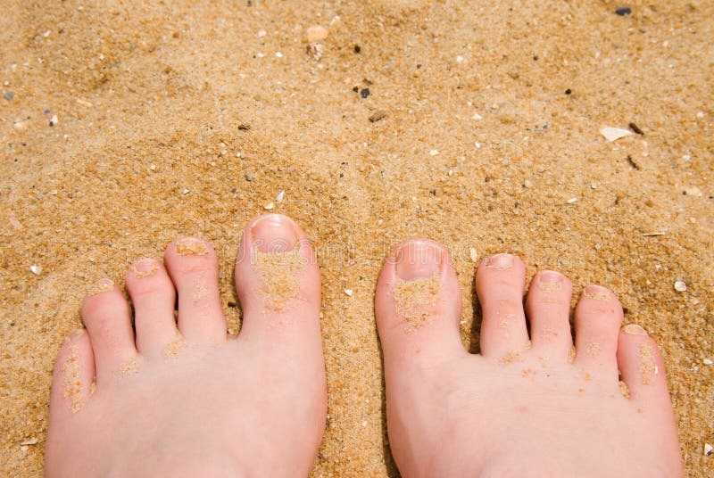 Woman's feet enjoying the feel of the sandy beach. Woman's feet enjoying the feel of the sandy beach