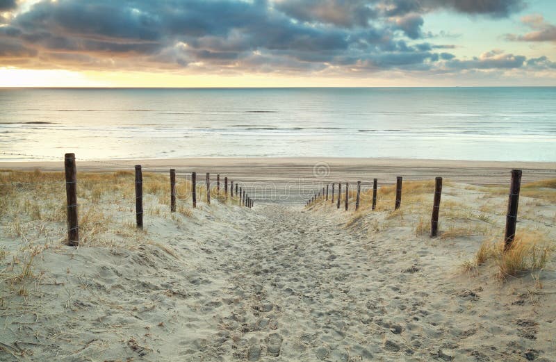 Sand path to the North sea at sunset