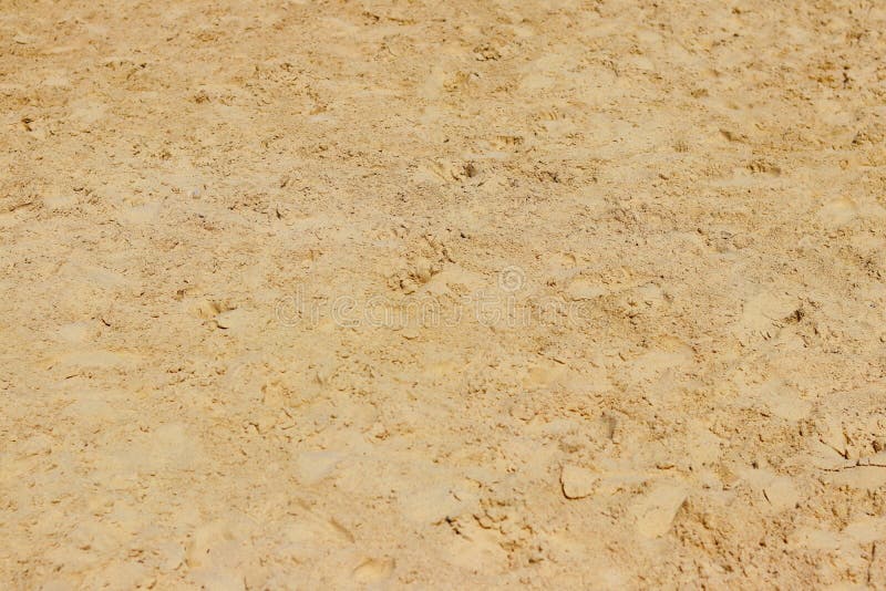 Sand relief stones texture of chaotic footprints. Naturale background yellow desert ground. Decoration of buildings and landscape.