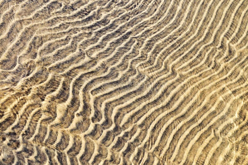 Sand ripples in shallow water stock photo