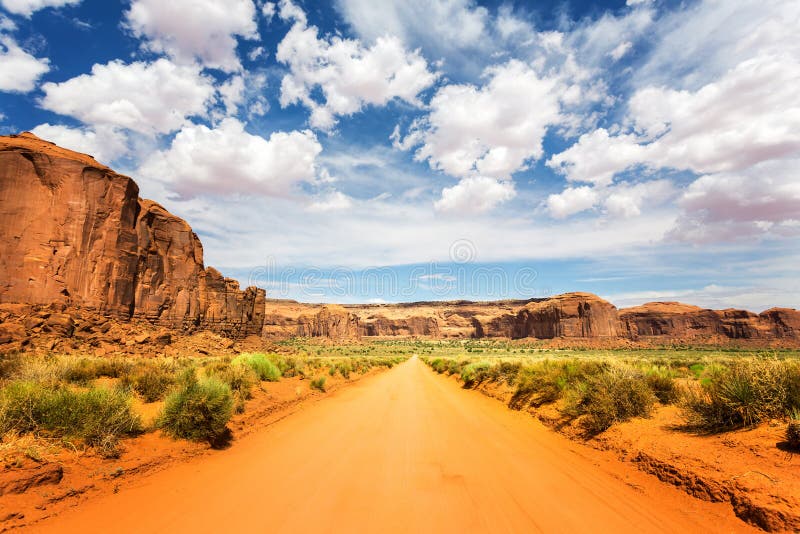 Sand road along red sandstones at Monument Valley