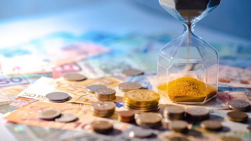 Hourglass and currency on table, Time Investment concept