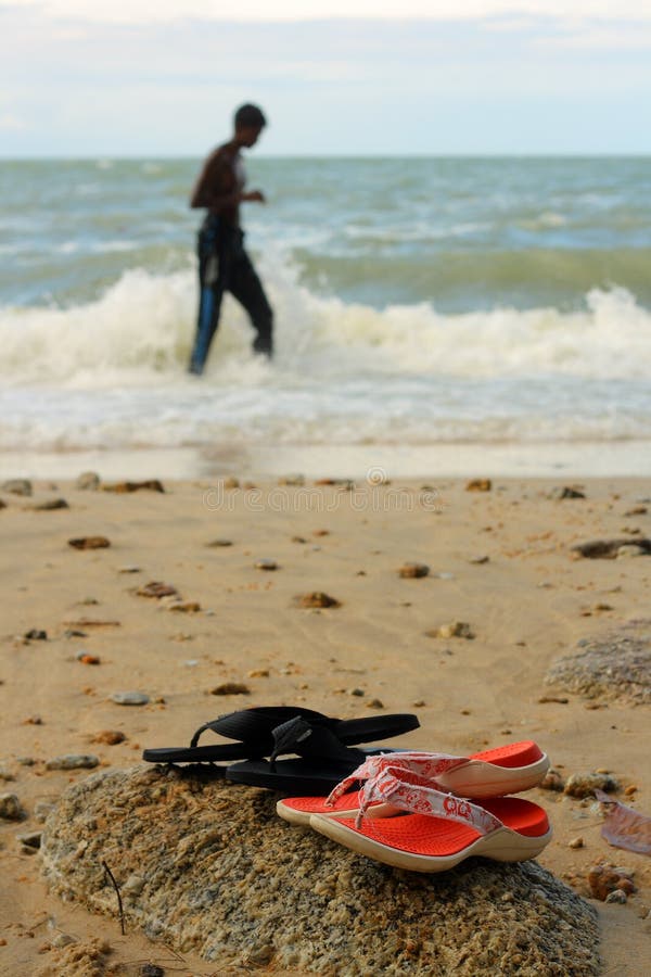 Sandals of a couple at beach. Boardwalk rail stock images, royalty-free photos and pictures