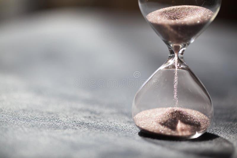 A sandglass, modern hourglass or egg timer with shadow showing the last second or last minute or time out.