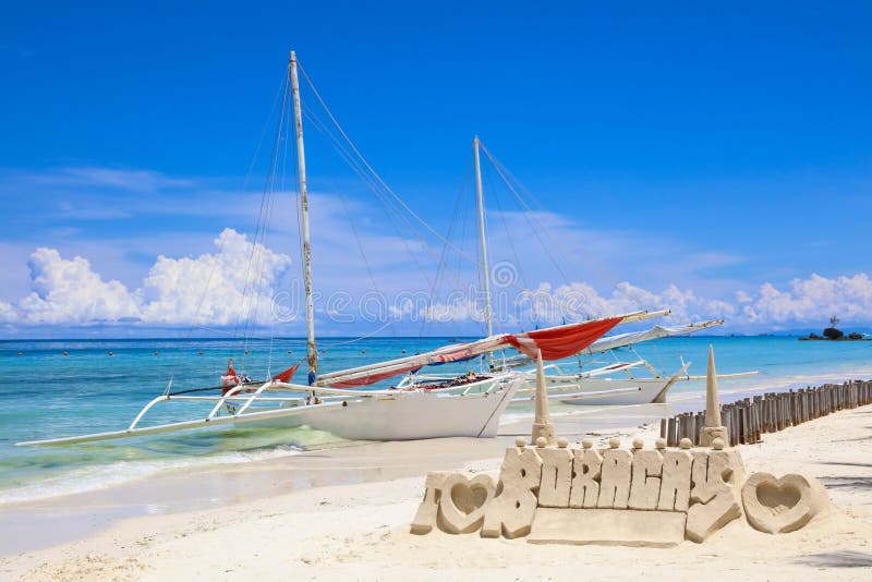 Sandslott och ett seglafartyg på den vita stranden, Boracay ö, Filippinerna royaltyfri bild Sandslott och ett seglafartyg på den vita stranden, Boracay ö, Filippinerna royaltyfri bild