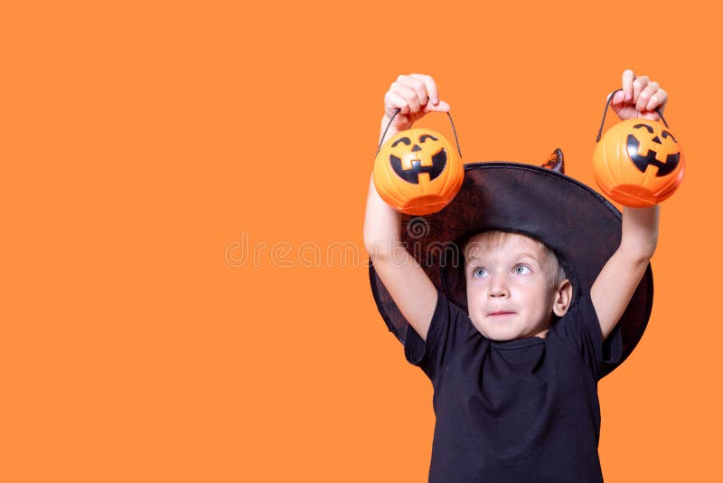 Crianças do dia das bruxas garotinho engraçado usando um chapéu de bruxa  com balões laranja e pretos feliz dia das bruxas