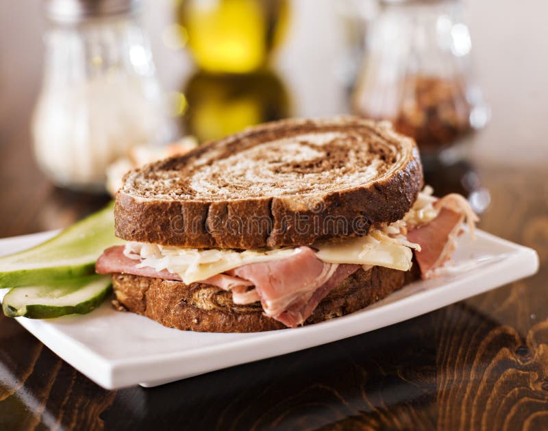 Close up photo of a reuben sandwich with kosher dill pickle and coleslaw. Close up photo of a reuben sandwich with kosher dill pickle and coleslaw