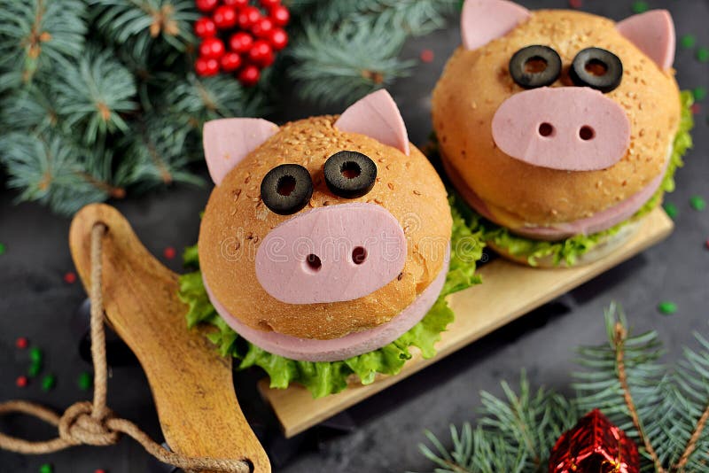 Sandwich avec du jambon, le fromage et la laitue sous forme de porc mignon - symbole de 2019 Fond de Noël du petit déjeuner des e photo libre de droits Sandwich avec du jambon, le fromage et la laitue sous forme de porc mignon - symbole de 2019 Fond de Noël du petit déjeuner des e photo libre de droits