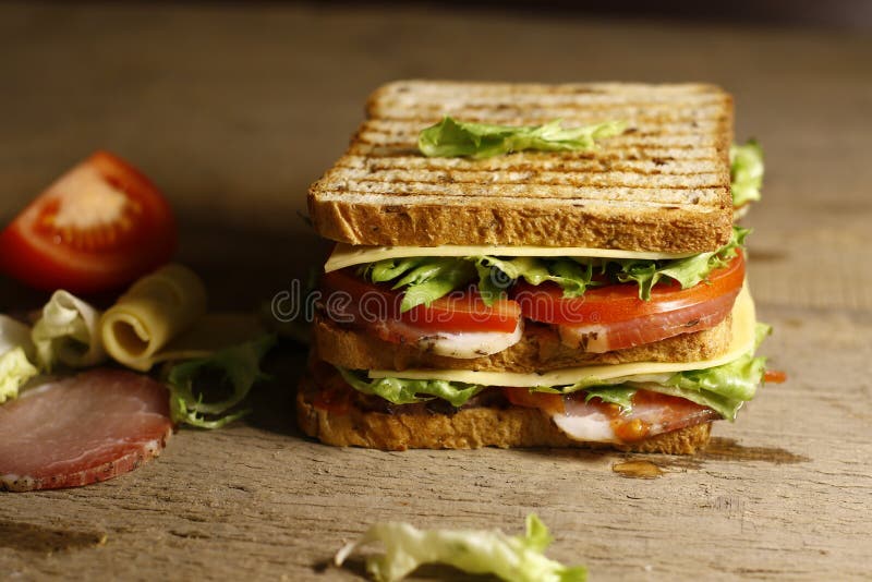 Sandwich avec le lard, la salade, le fromage et la tomate photographie stock Sandwich avec le lard, la salade, le fromage et la tomate photographie stock