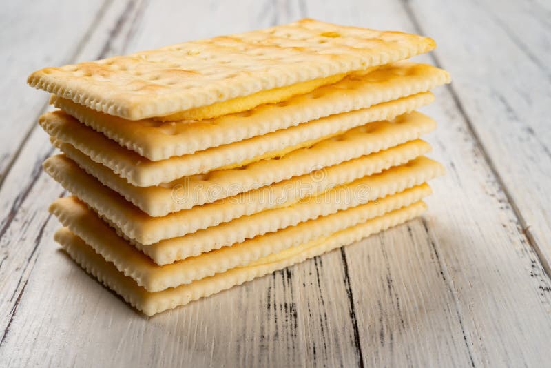 Sandwich biscuits with beige cream filling on white wood