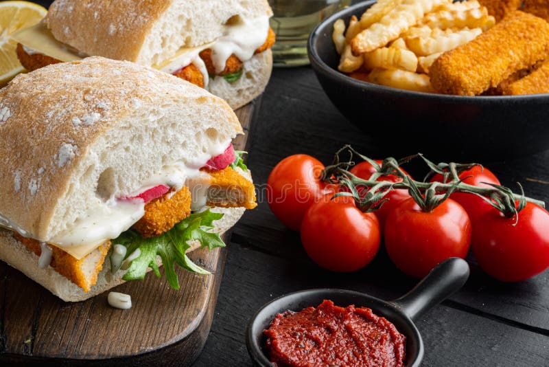 Sandwich with Fish Sticks, on wooden cutting board, on old dark wooden table background royalty free stock image.