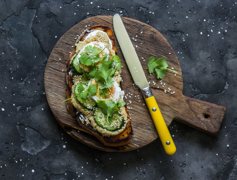 Sandwich with Hummus, Boiled Egg, Coriander on a Cutting Board on a