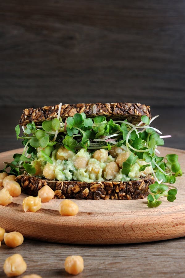 Sandwich à avocat de pois chiche avec des pousses de radis images libres de droits Sandwich à avocat de pois chiche avec des pousses de radis images libres de droits