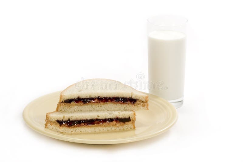 A peanut-butter and jelly sandwich with tall glass of milk on white background. A peanut-butter and jelly sandwich with tall glass of milk on white background