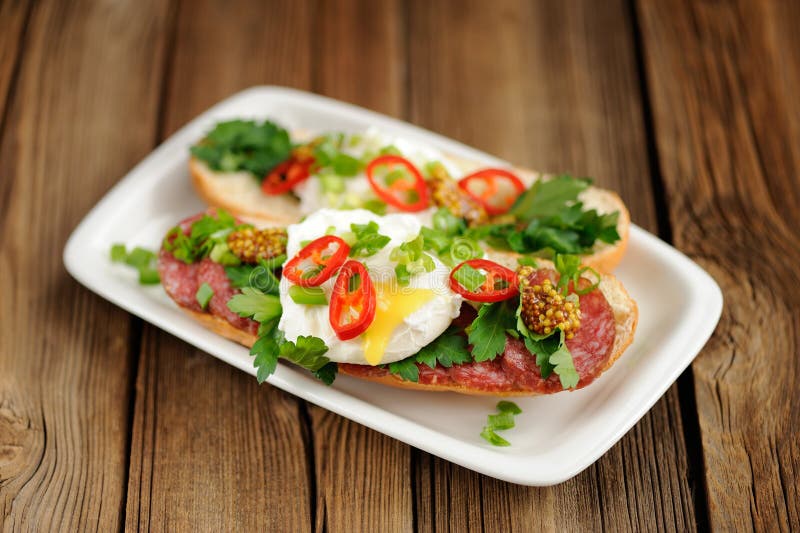 Sandwiche des poschierten Eies mit dem Paprika, Schalotte und Salami selektiv stockbilder Sandwiche des poschierten Eies mit dem Paprika, Schalotte und Salami selektiv stockbilder