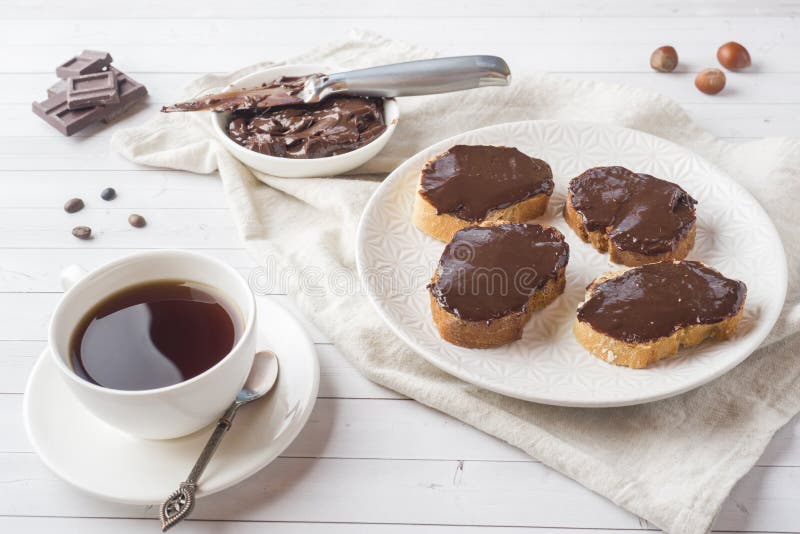 Sandwiches with Chocolate Hazelnut Spread on the Plate. Cup of Coffee on the Table. Stock Photo