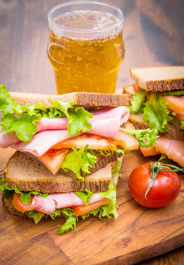 Sandwiches with ham and smoked salmon with beer glasses