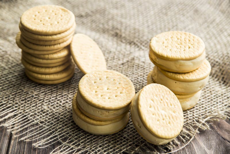 Sandwiches made from cookies and ice cream with condensed milk on a table with burlap