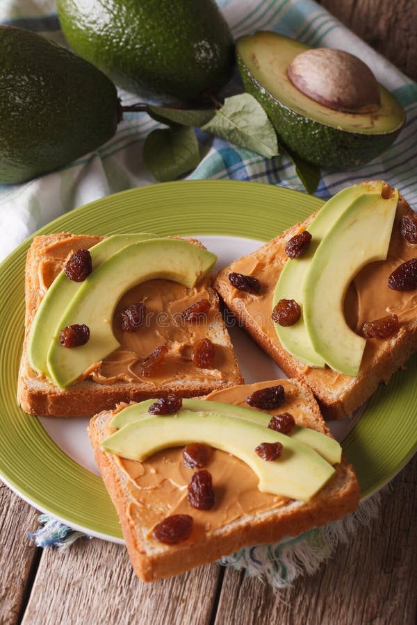 Sandwiches with peanut butter and ripe avocado closeup vertical