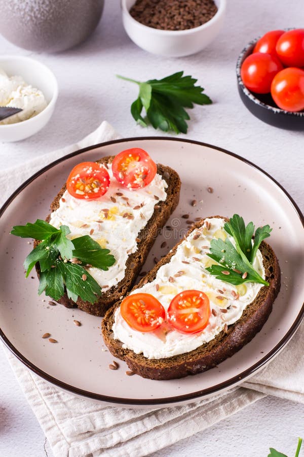 Sandwiches on Rye Bread with Ricotta, Tomatoes and Parsley on a Plate
