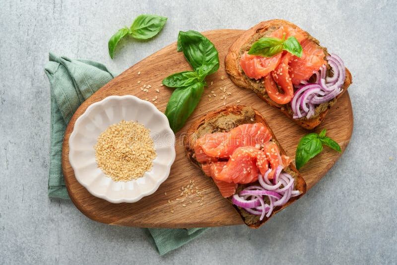 Sandwiches with salted salmon, avocado guacamole, red onions and basil. Smorrebrod. Set of danish open sandwiches. Healthy food