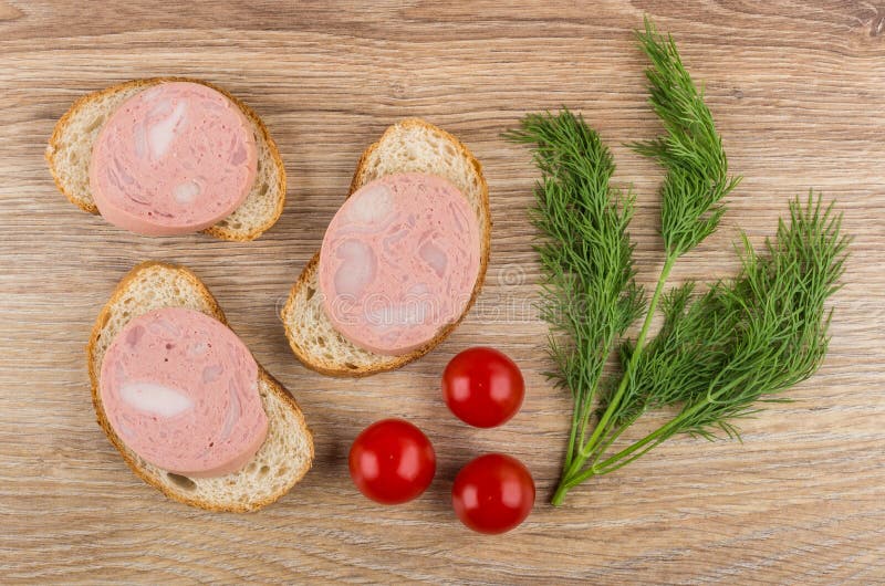 Sandwiches with sausage, tomato cherry and dill on wooden table