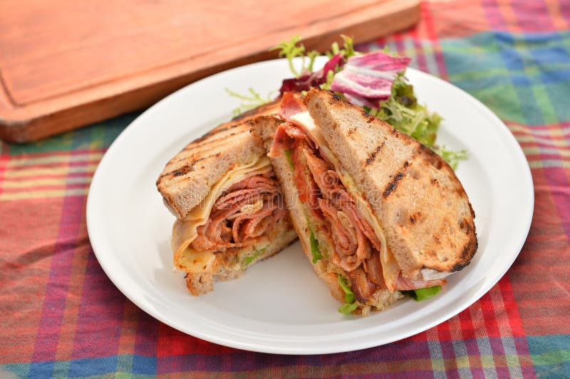 Sandwichs de lard et d'herbes du plat blanc sur la table image libre de droits Sandwichs de lard et d'herbes du plat blanc sur la table image libre de droits