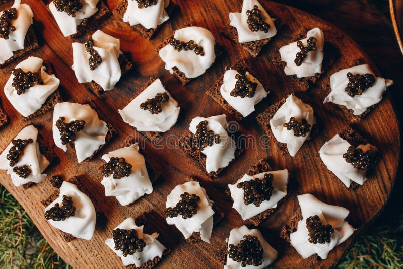 Sandwichs délicieux avec le caviar et le fromage noirs sur une vue supérieure de conseil en bois photos stock Sandwichs délicieux avec le caviar et le fromage noirs sur une vue supérieure de conseil en bois photos stock