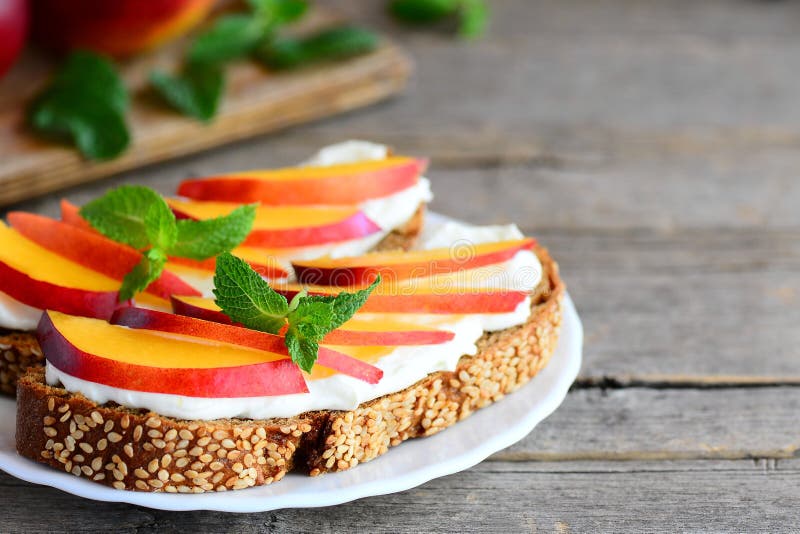 Sandwichs à pain grillé de fromage de nectarine et fondu Sandwichs ouverts faits de pain de seigle avec le fromage fondu et les t images stock Sandwichs à pain grillé de fromage de nectarine et fondu Sandwichs ouverts faits de pain de seigle avec le fromage fondu et les t images stock