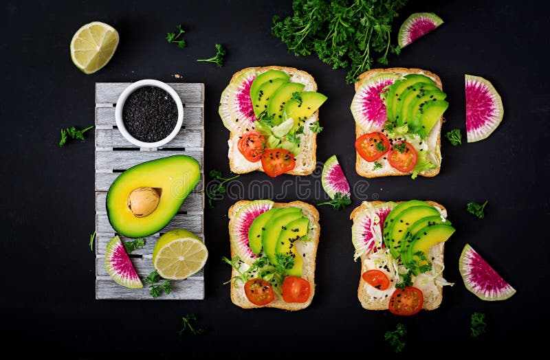 Sandwichs à Vegan avec l'avocat, le radis de pastèque et les tomates image stock Sandwichs à Vegan avec l'avocat, le radis de pastèque et les tomates image stock