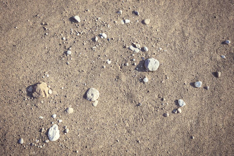 Sandy beach background with a handful of small stones