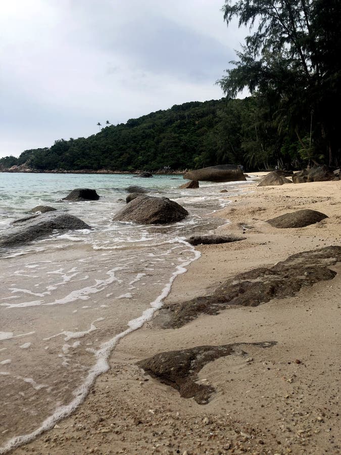 Sandy beach with large rocks and sea wave stock photos Sandy beach with large rocks and sea wave stock photos