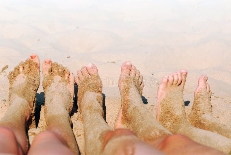 Row of children's feet on a beach covered in sand. Row of children's feet on a beach covered in sand