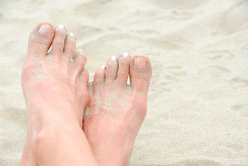 Crossed sandy feet on a beach