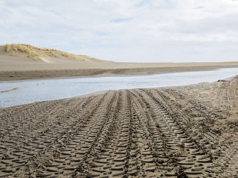 Sandy Road with a Set of Tire Tracks Leading through it. Stock Photo