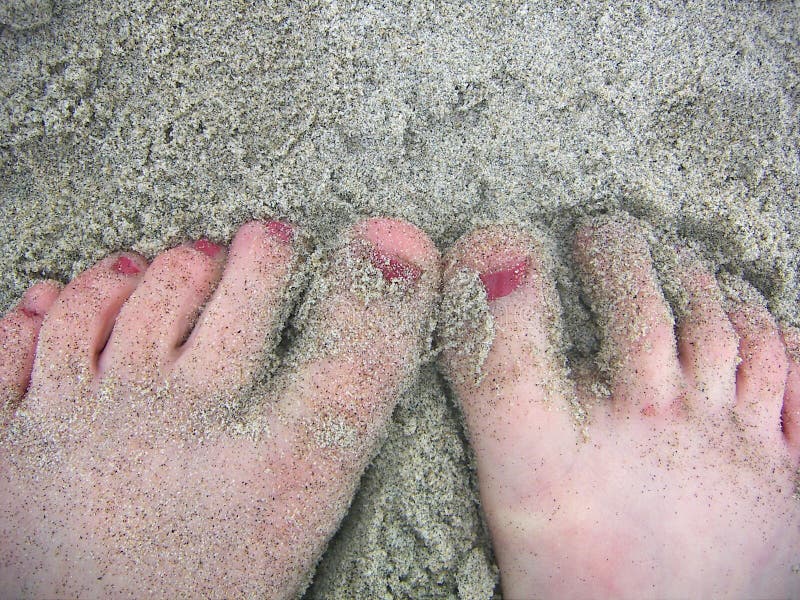 A little girl's painted toes in the sand at the beach. A little girl's painted toes in the sand at the beach