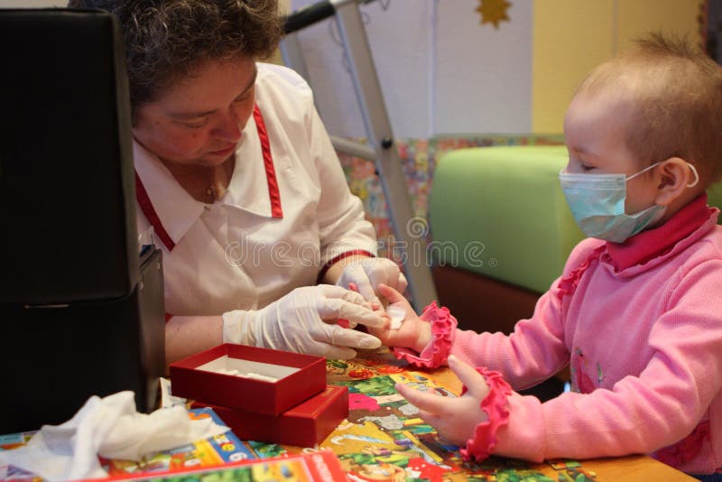 Tomsk, Russia - June 25, 2009: The doctor gets unidentified childâ€™s blood tested in Department of Pediatric Oncology and Hematology on Tomsk Regional Clinical Hospital. The Department of Pediatric Oncology and Hematology. Tomsk Regional Clinical Hospital. Ill children live here together with their mothers. Leukemia (a blood cancer), anemia, hemophilia â€“ these diseases rank second in the statistics of mortality of children under the age of 14. First rank is the accidents (injuries and poisoning). In case of blood cancer the most important thing is to diagnose it in time. If the illness was detected early and the treatment was picked up correctly, the probability of treatment or transition in a condition of long remission at children makes 80-90 percent. In Russia during the last years the survival rate at a blood cancer has grown with 4 to 80 percent. Tomsk, Russia - June 25, 2009: The doctor gets unidentified childâ€™s blood tested in Department of Pediatric Oncology and Hematology on Tomsk Regional Clinical Hospital. The Department of Pediatric Oncology and Hematology. Tomsk Regional Clinical Hospital. Ill children live here together with their mothers. Leukemia (a blood cancer), anemia, hemophilia â€“ these diseases rank second in the statistics of mortality of children under the age of 14. First rank is the accidents (injuries and poisoning). In case of blood cancer the most important thing is to diagnose it in time. If the illness was detected early and the treatment was picked up correctly, the probability of treatment or transition in a condition of long remission at children makes 80-90 percent. In Russia during the last years the survival rate at a blood cancer has grown with 4 to 80 percent.