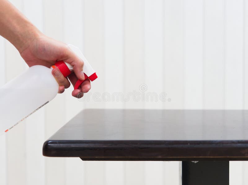 Sanitizing Table with Alcohol Disinfectant Spray Bottle in Restaurant