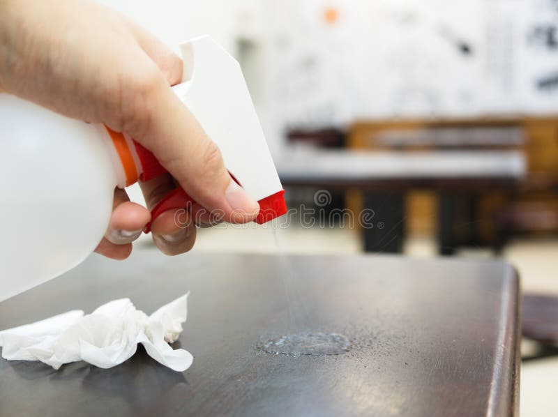 Sanitizing Table with Alcohol Disinfectant Spray Bottle in Restaurant