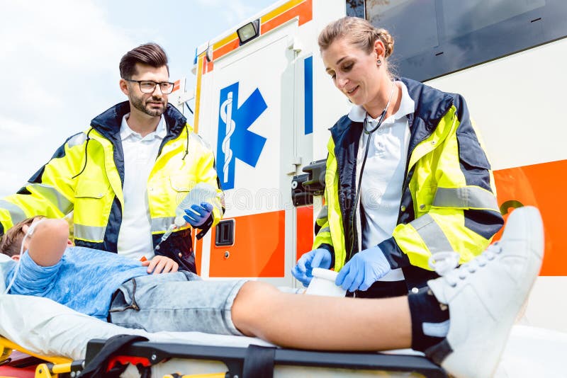 Sanitäter und Notfall behandeln das Interessieren für verletzten Jungen stockbild Sanitäter und Notfall behandeln das Interessieren für verletzten Jungen stockbild