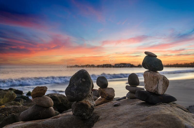 Santa Barbara tropical beach sunset with stacked balanced rocks, piece and harmony concept. Santa Barbara tropical beach sunset with stacked balanced rocks, piece and harmony concept