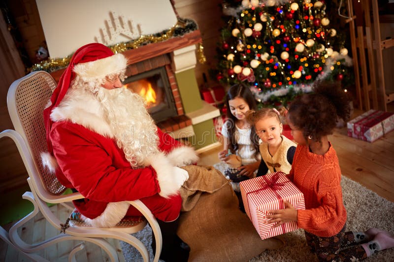Santa Claus die een heden geven aan een weinig leuk meisje voor h royalty-vrije stock foto Santa Claus die een heden geven aan een weinig leuk meisje voor h royalty-vrije stock foto