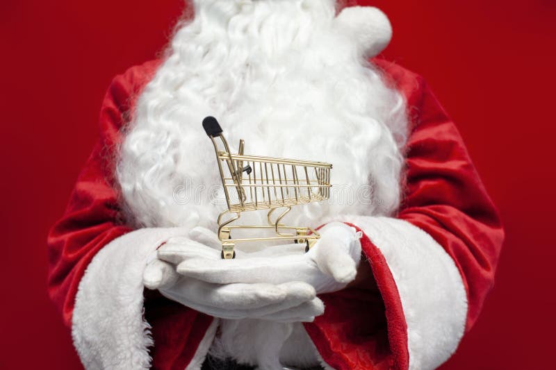 Santa claus en costume et gants tient vide panier vide petit chariot vide se tient sur les mains de l'homme images stock