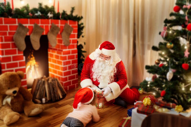 Santa Claus en el piso en la casa da a regalos al niño i fotografía de archivo libre de regalías Santa Claus en el piso en la casa da a regalos al niño i fotografía de archivo libre de regalías