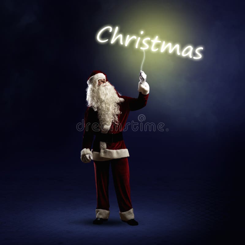 Santa Claus está llevando a cabo una palabra brillante de la Navidad imagenes de archivo Santa Claus está llevando a cabo una palabra brillante de la Navidad imagenes de archivo