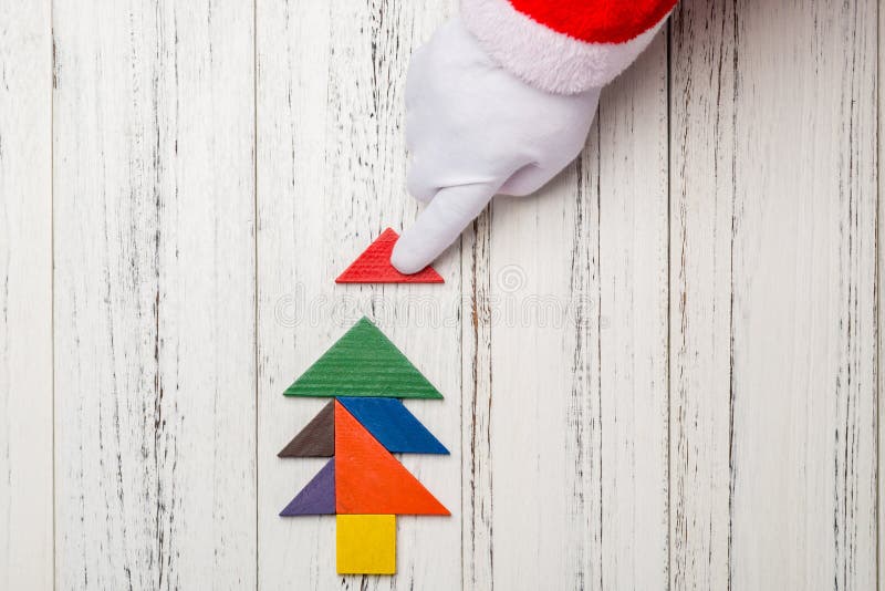 Santa claus finishing the last bit of Christmas tree made by wood tangram royalty free stock photography Santa claus finishing the last bit of Christmas tree made by wood tangram royalty free stock photography