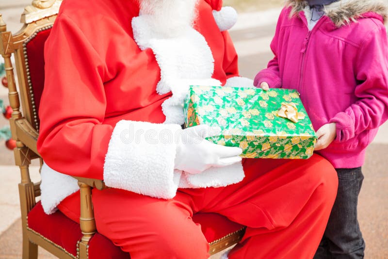 Santa Claus Giving Christmas Gift To Girl stock photography