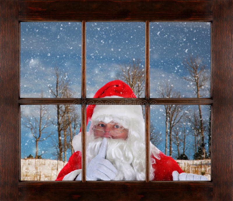 Santa Claus kickade i fönstret och gjorde Shh-skylt, finger till munnen, med snövintrar i bakgrunden royaltyfria bilder